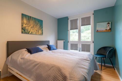 a bedroom with a bed with blue walls and a chair at Ferienhaus-Ivory-in-Binz in Binz