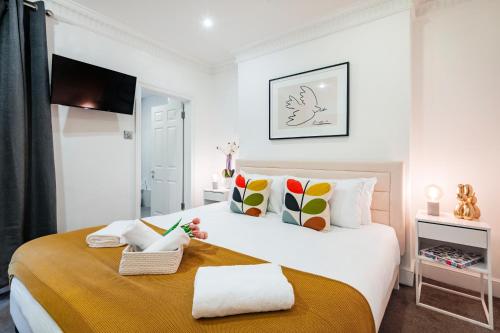 ein Schlafzimmer mit einem großen weißen Bett mit bunten Kissen in der Unterkunft Welcome London Leicester Square in London