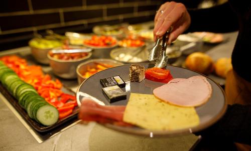 a person is preparing food on a table at Kedi Hotel Papenburg in Papenburg