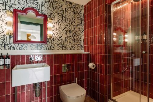 a bathroom with a toilet and a sink and a mirror at room2 Belfast Hometel in Belfast