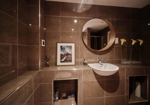 uma casa de banho com um lavatório e um espelho em The Steadings, Aviemore Luxury 5 star rated 3 Bed with home cinema garden and parking em Aviemore