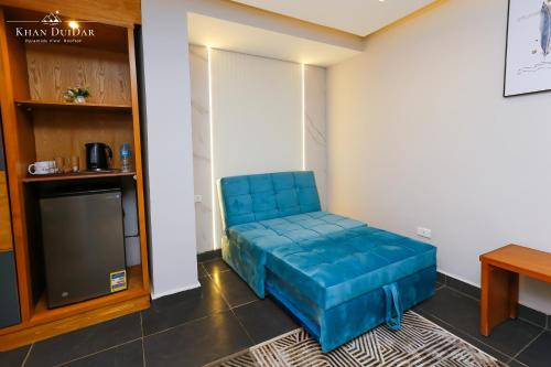 a blue couch in a room with a tv at Khan Duidar Inn - Pyramids View Rooftop in Cairo