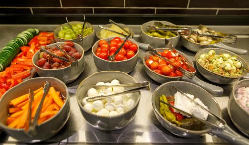 a buffet with many bowls of different types of food at Kedi Hotel Papenburg in Papenburg