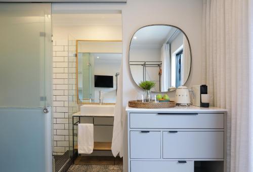 a bathroom with a sink and a mirror at Twice Central Guest House in Stellenbosch