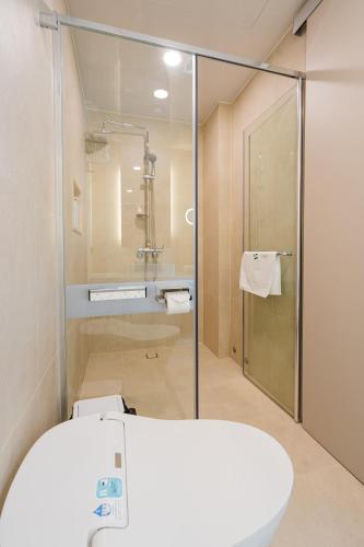 a bathroom with a glass shower and a sink at Hotel Vert in Seoul