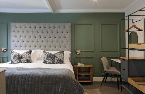 a bedroom with a large bed and a green wall at Twice Central Guest House in Stellenbosch