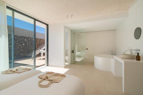 een witte badkamer met een bad en een wastafel bij Areté in Mácher