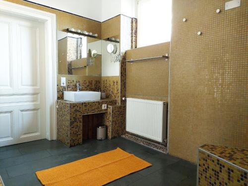 uma casa de banho com um lavatório e um chuveiro com um espelho. em Hidden Garden - 160 m² - 1 min to City Shuttle em Viena