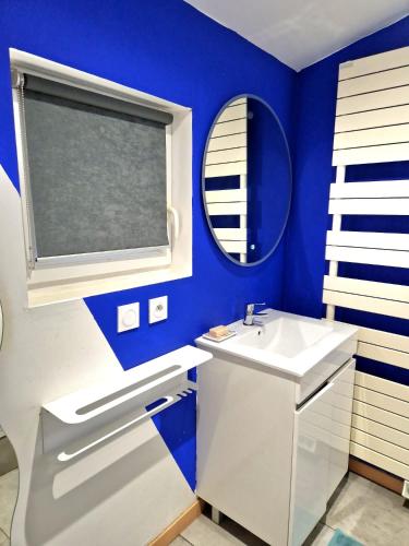 une salle de bain bleue avec un lavabo et un miroir dans l'établissement Petit studio avec terrasse, à Toulouse