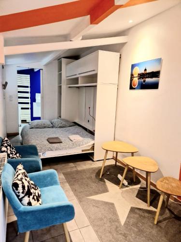 - un salon avec un lit, un canapé et des tables dans l'établissement Petit studio avec terrasse, à Toulouse