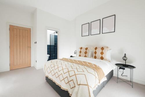 Un dormitorio blanco con una cama grande y una puerta en Modern & Bright Luxury London Apartment in Honor Oak, en Londres