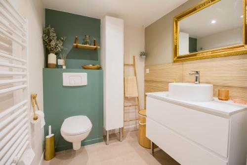 ein Badezimmer mit einem weißen Waschbecken und einem Spiegel in der Unterkunft Elégante escale à Orly in Orly