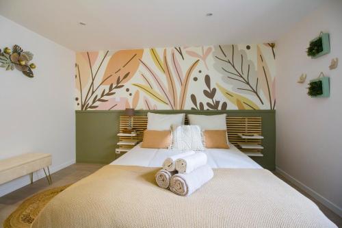 a bedroom with a large bed with towels on it at Elégante escale à Orly in Orly