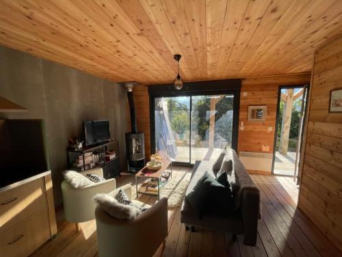 un salon avec un canapé, des chaises et une télévision dans l'établissement Les 2 louveteaux, à Uvernet