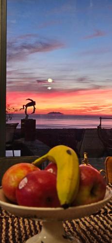 PorriにあるDomaine COLONNA SANTINI ,Chambre d hôtes Piscine, Spaのテーブルの上にリンゴとバナナの皿