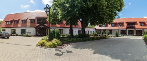 a building with a tree in front of it at Hotel Folwark in Zgierz