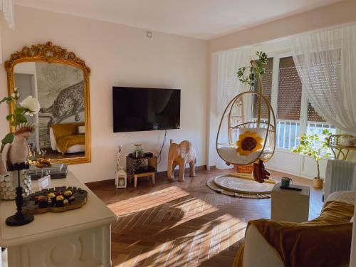een woonkamer met een grote spiegel en een bank bij Rose Blossom apartment in Paris in Vanves