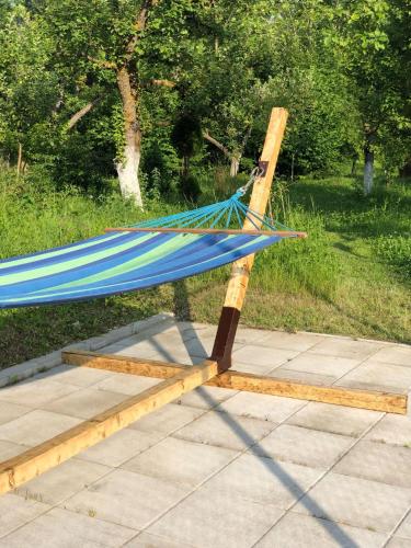 a hammock on a wooden stand on a patio at Pensiunea Soreanca in Costeşti