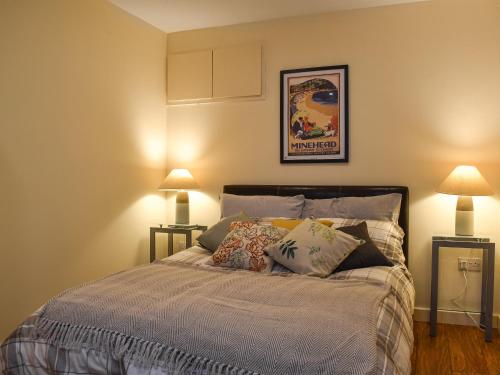 1 dormitorio con 1 cama con almohadas y 2 lámparas en Walnuts Nest en Minehead