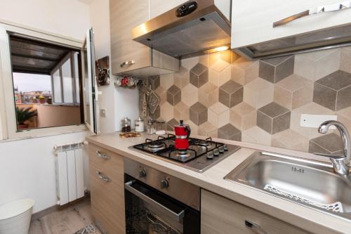 cocina con fogones horno de arriba junto a un fregadero en sweet home station, en Roma