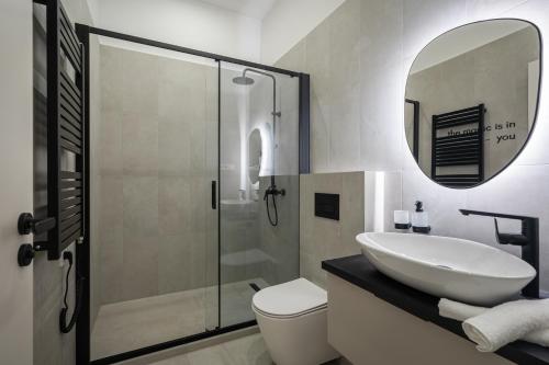 a bathroom with a sink and a toilet and a mirror at You Boutique Suites, Best Location by BQA in Budapest