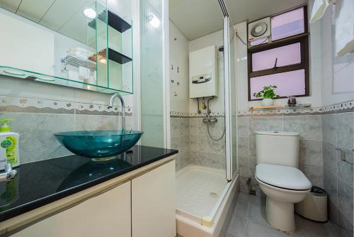 een badkamer met een wastafel, een toilet en een douche bij Tsim ShaTsui Luxury 3bedroom Apartment near MTR！ in Hong Kong