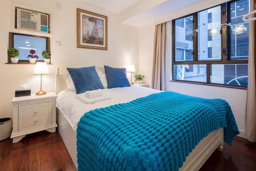 ein Schlafzimmer mit einem großen Bett und einem Fenster in der Unterkunft Tsim ShaTsui Luxury 3bedroom Apartment near MTR！ in Hongkong
