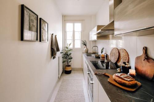 - une cuisine avec un comptoir et du pain dans l'établissement Royo - 1 chambre à Auteuil, à Paris