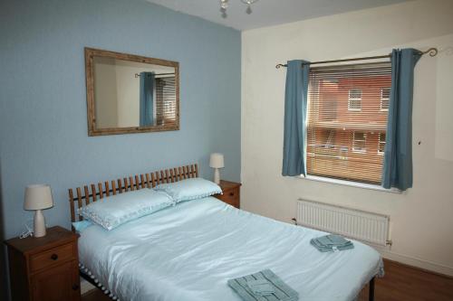 a bedroom with a bed with a mirror and a window at Doncaster - Town Centre - 2 Bedrooms & Sofa Bed - Very Quiet Location in Doncaster