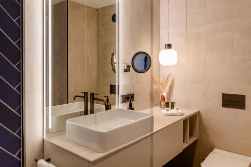 uma casa de banho com um lavatório branco e um espelho. em Atlanta Hotel Leipzig em Leipzig