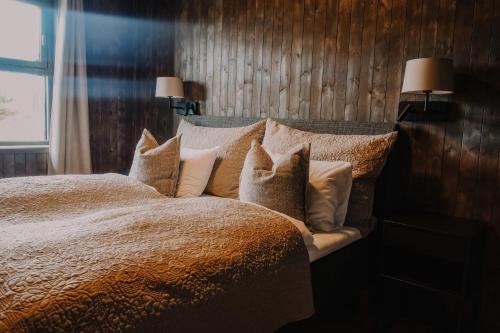 a bedroom with a bed with pillows and a window at Pellestova Hotell Hafjell in Hafjell