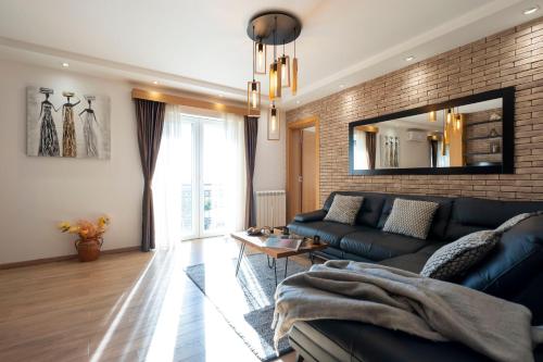 a living room with a blue couch and a brick wall at 1-Bedroom Apartment with Balcony in Ledine
