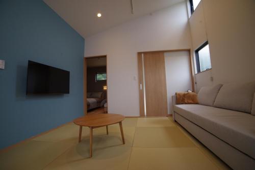 a living room with a couch and a table at SAKURA YAKUSHIMA in Yakushima