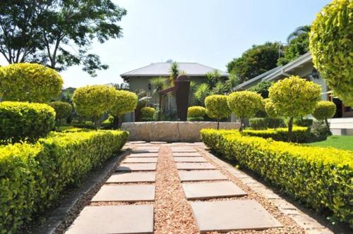 a garden with a walkway in front of a house at Limpopo Guest Manor in Polokwane