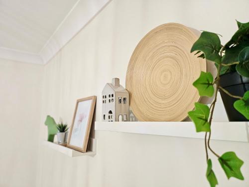 a shelf with a straw hat and a picture at Cosy 3BR House, 7 mins drive to Macquarie Centre, 5 stars on AirB&B in Sydney