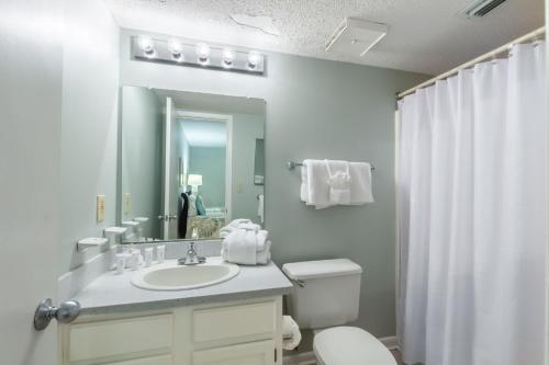 bagno con lavandino, servizi igienici e specchio di Phoenix I 1085 a Orange Beach