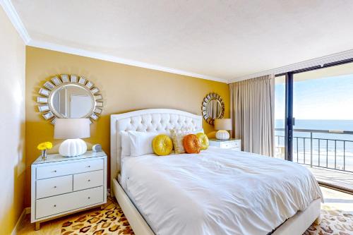 1 dormitorio con cama blanca y balcón en King Luis - B en Galveston