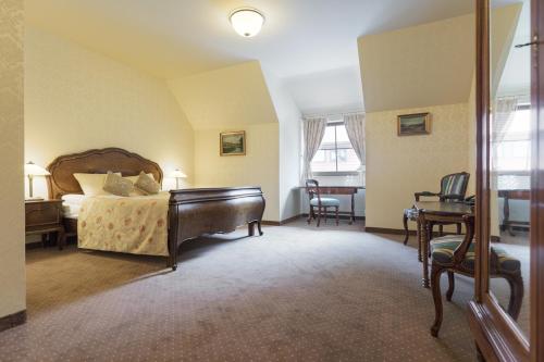 a bedroom with a bed with a piano and a desk at Hotel Folwark in Zgierz
