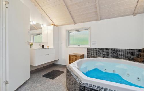 ein Badezimmer mit einer großen Badewanne und einem Waschbecken in der Unterkunft Gorgeous Home In Ebeltoft With Wifi in Ebeltoft