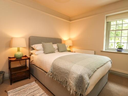 a bedroom with a large bed and a window at Upper Lodge in Bowness-on-Windermere