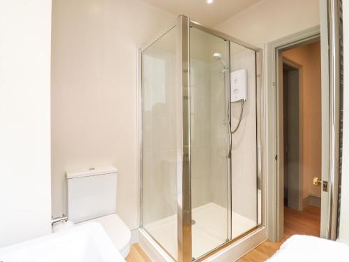 a glass shower in a room with a toilet at Upper Lodge in Bowness-on-Windermere