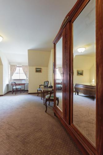 a living room with a mirror and a couch at Hotel Folwark in Zgierz