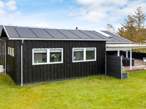 una casa negra con techo inclinado en 8 person holiday home in Hals en Hals