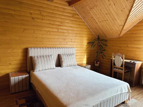a bedroom with a bed and a wooden wall at Сонячний Лаз in Polyana