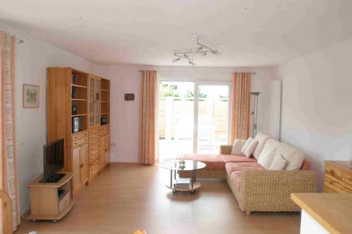 Una sala de estar con un sofá y un televisor. en Ferienwohnung Dr Saretz, en Bodman