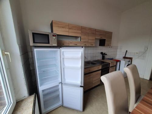 een keuken met een witte koelkast en een magnetron bij Seeadler-1-6-Personen in Brunsbüttel