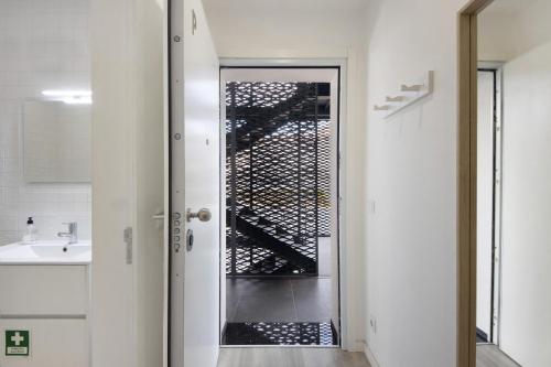 uma casa de banho com uma porta de vidro que leva a uma escada em Coração de Aveiro em Aveiro