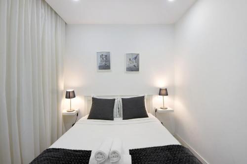 um quarto com uma grande cama branca e 2 candeeiros em Coração de Aveiro em Aveiro