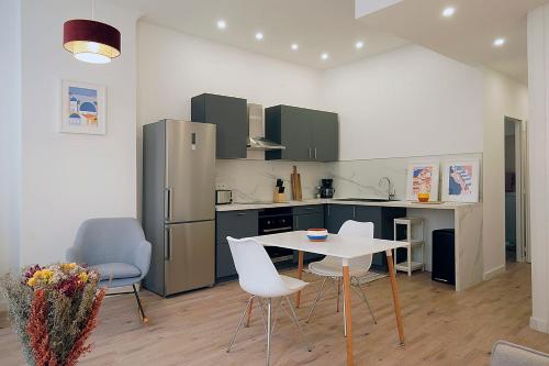 une cuisine avec une table, des chaises et un réfrigérateur dans l'établissement Beautiful cocoon 54 m for 4 near the Old Port, à Marseille