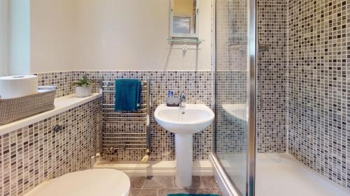 uma casa de banho com um WC, um lavatório e um chuveiro em Impeccable 4-Bed House in London em Londres